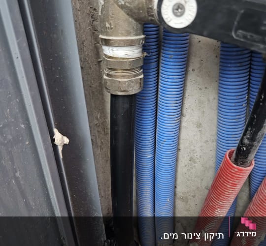 צינורות מים וצנרת צבעונית בקיר בטון